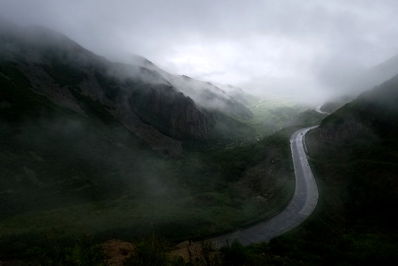 Misty view of curvy mountain road.